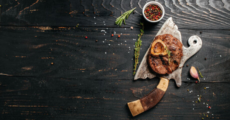 grilled fresh cross cut veal shank for making Osso Buco on meat cleaver. Long banner format. top view