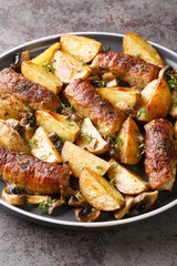 Baked pork rolls with mushrooms and potatoes close-up in a plate on the table. Vertical
