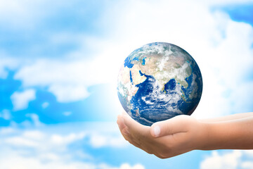Earth in hand. Handshake the earth on a blurry natural sky background. Elements of this image furnished by nasa.