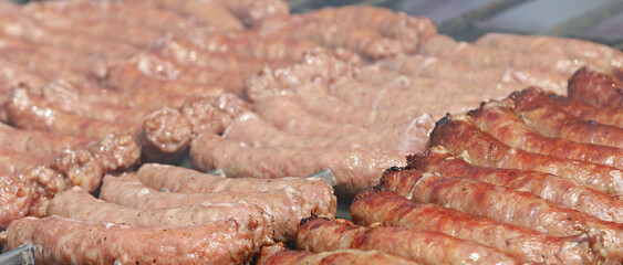 sausages and salami cooked on a spit in a rotisserie