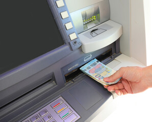 hand who withdraws money in european twenty euro banknotes in the atm automatic teller machine