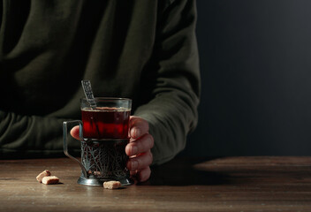 Man holds a traditional Russian glass holder with hot tea.