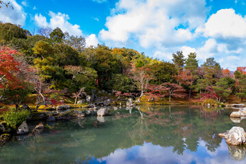 Fototapeta na wymiar 秋の京都・天龍寺で見た、色鮮やかな曹源池庭園の紅葉と青空に浮かぶ雲