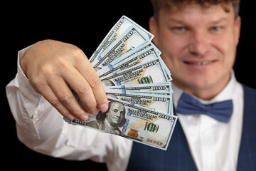 A croupier with a bundle of dollars in his hands