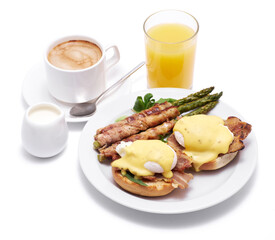 Healthy food - Asparagus wrapped with bacon and benedict poached eggs on a plate isolated on white background