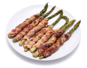 Healthy food - Asparagus wrapped with bacon and spices on a plate isolated on white background