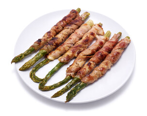 Healthy food - Asparagus wrapped with bacon and spices on a plate isolated on white background