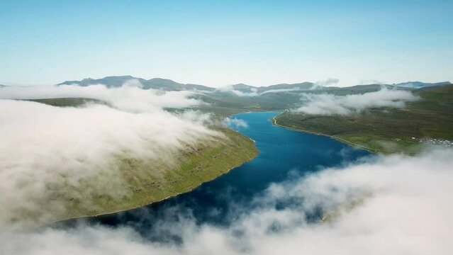 Aerial view of Sorvagsvatn lake or Leitisvatn, Biggest lake in Faroe Islands. Flying through the clouds. Amazing mist and foggy Faroese nature. High quality 4k footage.