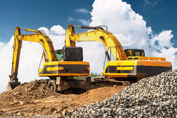 Powerful excavators at a construction site against a blue cloudy sky. Earthmoving construction...