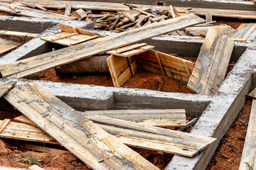 Dismantling the strip foundation formwork at the construction site. Dismantling of wooden formwork panels after concrete hardening. Foundation works.