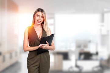 Fototapeta premium Businesswoman is standing holding clipboard at office workplace