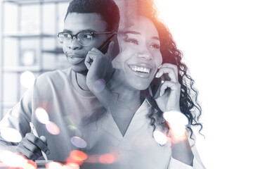 Smiling attractive businesswoman is talking to businessman on ph