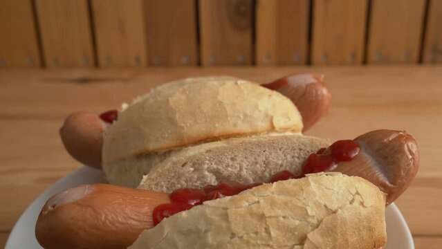 Boiled sausage with a bun on a wooden background. Bockwurst with a bun.