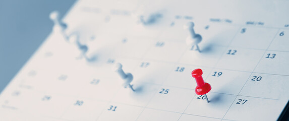 Embroidered red pins on a calendar event Planner calendar,clock to set timetable organize schedule,planning for business meeting or travel planning concept.