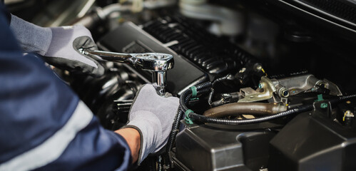 Fototapeta na wymiar Professional mechanic working on the engine of the car in the garage. Car repair service.
