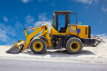 Grader and yellow bulldozer on construction site and sky background