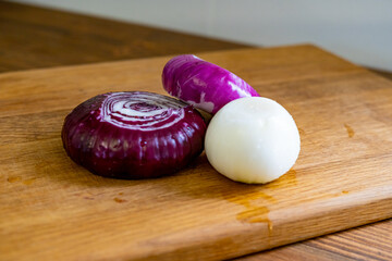 red and white onions on a wooden cutting board