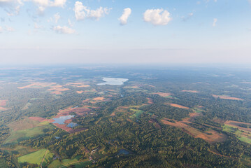 Aerial view of fields, forests and lake on a sunny summer morning, Latvia.