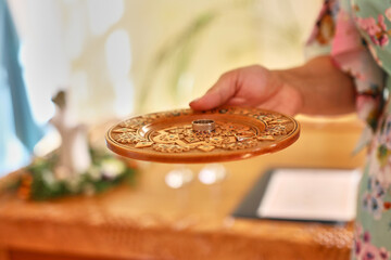 Wedding rings on a carved wooden plate.