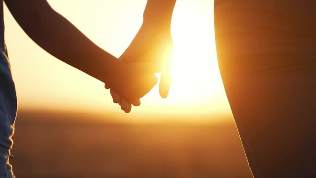 happy family. mom and daughter hold hands close up. mother and baby girl hands together at sunset. parent girl and child happy childhood. lifestyle happy family mothers together day concept
