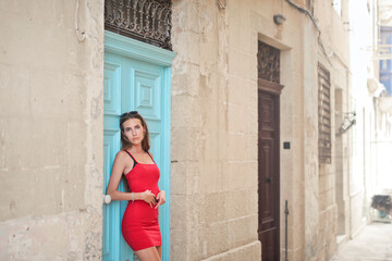 Fototapeta na wymiar young woman leaning against a door of a house