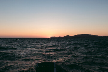 Pretty sunset behind mountains at sea