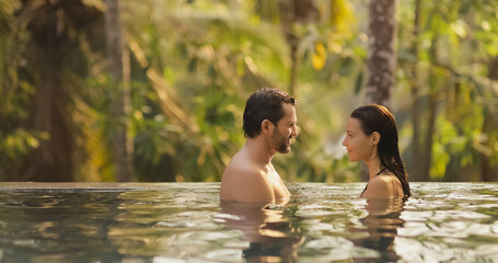 Couple in Love Together in Infinity Swimming Pool Outdoors During