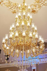 Ceiling chandelier of classic vintage style shape made of crystal and glass with lamps.