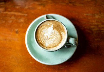 Close up photo of latte coffee on wooden table.