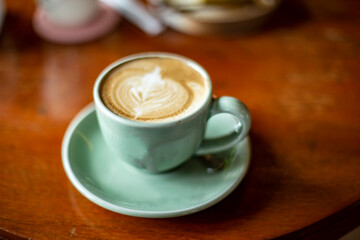 Close up photo of latte coffee on wooden table.