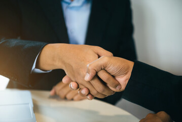 Businessmen shake hands after agreeing to start a new project successfully.