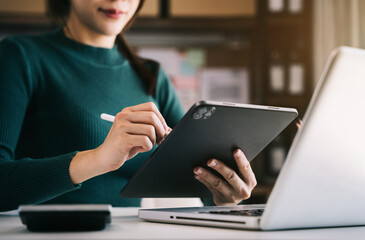 Businesswomen working with tablet and laptop computer in office.