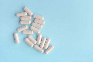 white pills on blue table. Medical, pharmacy and healthcare concept. Copy space. Place for text or logo. Mock up for special offers as advertising or other ideas.