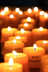 Mehrere brennende orangefarbene Opferkerzen Gedenkkerzen, vertikal, schwarzer Hintergrund 