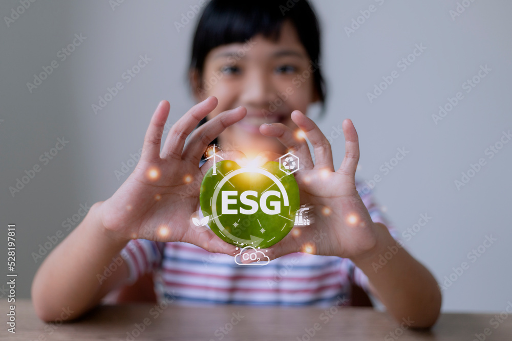 Wall mural ESG text symbol on kid hands green leaf eco background, creative eco environment investment fund, future green energy innovation business trend.ESG of environmental Icon.