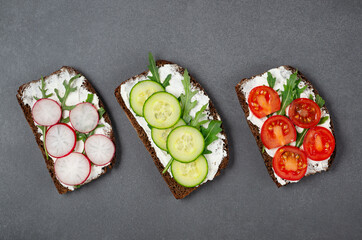 Healthy sandwiches with white cottage cheese, cucumber, arugula, tomato