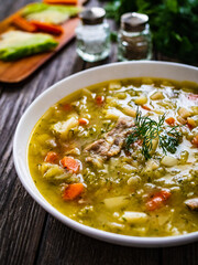 Bowl of hot cabbage soup on wooden table
