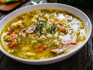 Bowl of hot cabbage soup on wooden table
