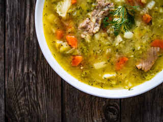 Bowl of hot cabbage soup on wooden table
