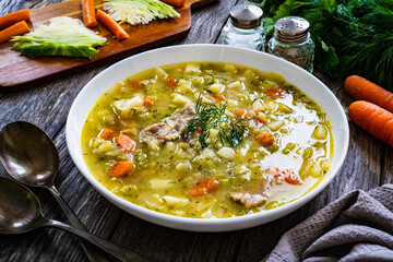 Bowl of hot cabbage soup on wooden table
