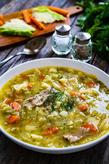Bowl of hot cabbage soup on wooden table
