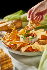 corn nachos with guacamole on a light background in the rays of the sun