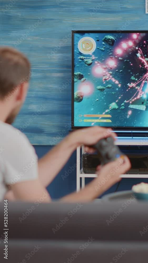 Poster man holding controller playing action space shooter on console disappointed because losing online ga