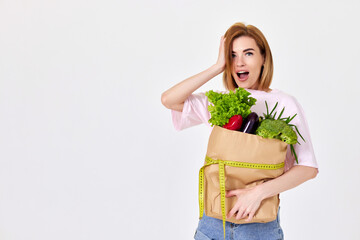 caucasian woman hold paper bag with vegetables