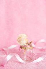 glass vase with decorative flowers on a light pink background