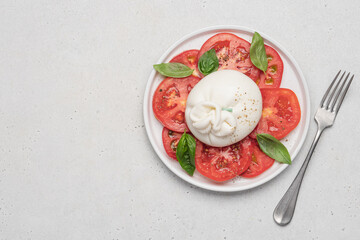 Tomato salad with buratta cheese or mozzarella and basil. Traditional italian salad, mediterranean cuisine