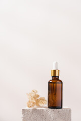 Serum in glass bottle with pipette stands on concrete stone podium on white background. Beauty skin  care concept