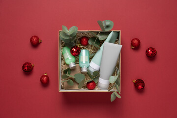 Beauty box with face and body care products on  red background. Tubes with cream and lotion, soap,...