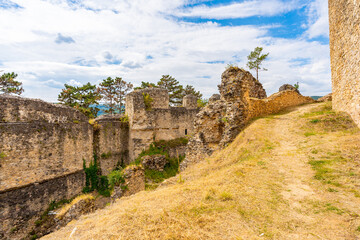 Fototapeta premium calming view through the ruins of Castle Divin, Slovakia, Europe, blue cloudy sky, pine trees in the sky