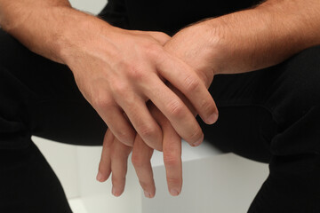 The man sits with his arms folded calmly. Close-up of men's hands. The concept of sadness, bad mood, hopelessness or just a calm state of a person.